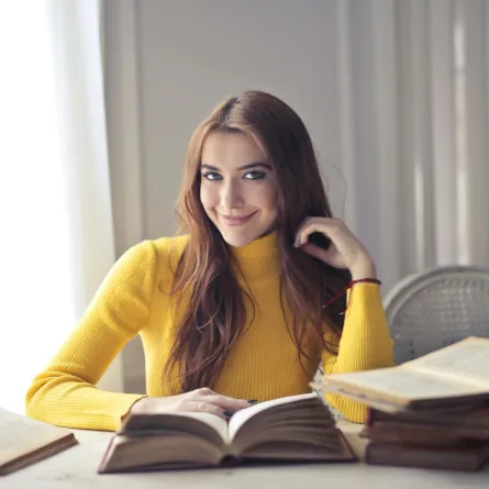 شابة تقرأ عدداً من الكتب في إدارة الأعمال والقيادة 