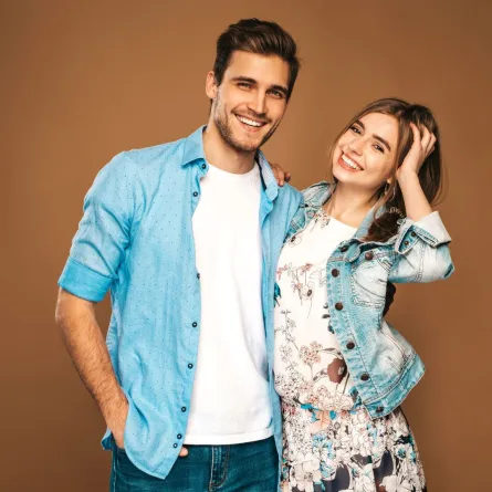 زوجان سعيدان مبتسمان والزوج يضع يده على وسط زوجته بمودة  