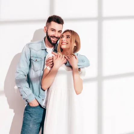 زوج يحتضن ظهر زوجته وهي تضحك بسعادة   