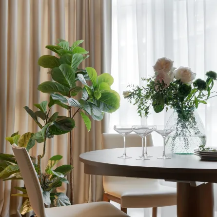 غرفة طعام مودرن مع إضاءة حائطية وزينة عبارة عن شجرة تين الكمان