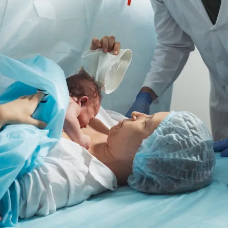 صورة لأم تمسك بالمولود الجديد