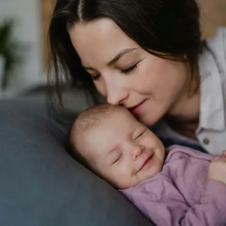 صورة لأم ومولودها نائم بشكل صحيح