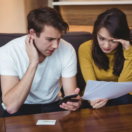 زوجان يناقشان مشالكهما المالية بغرض الوصول لطريقة لحلها