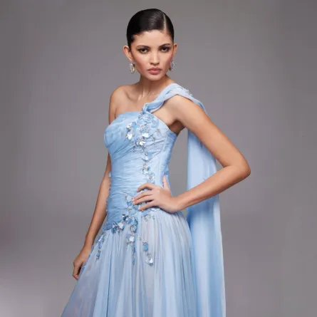 الفستان الأزرق المطرَّز باللؤلؤ والكريستال بقصة كتف واحدة -الصورة من نور الظاهري 