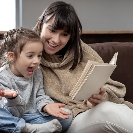 صورة لأم تقرأ قصة لطفلتها
