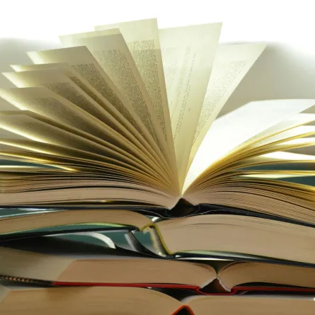 مجموعة من الكتب وفوقها كتاب مفتوح