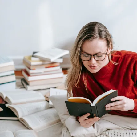 شابة تقرأ مجموعة من كتب السيرة الذاتية 