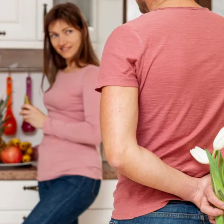 زوج يحمل زهوراً هدية لزوجته بعد عودته من السفر  