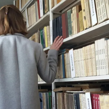 شابة تبحث عن كتاب في مكتبة 
