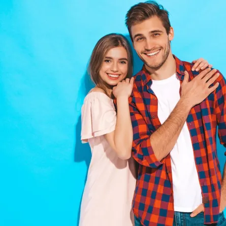 زوجة شابة مبتسمة تستند تحتضن كتف زوجها بسعادة