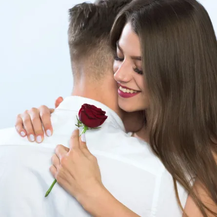 زوج أهدى لزوجته زهرة حمراء وهي تحتضنه بمحبة