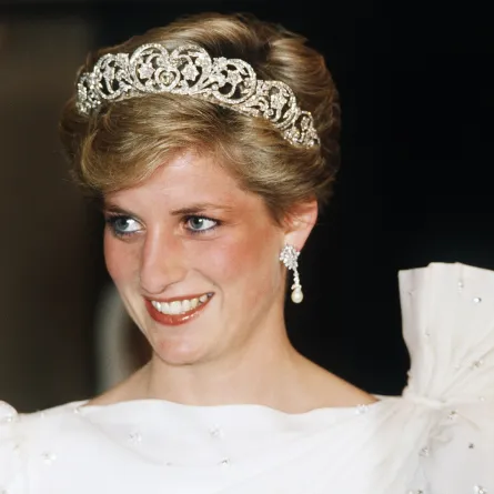 الأميرة ديانا، أميرة ويلز، Diana, Princess of Wales ترتدي فستانًا أبيض من تصميم ديفيد وإليزابيث إيمانويل، وتضع تاج سبنسر، خلال حضورها مأدبة رسمية في 16 نوفمبر 1986 في البحرين. مصدر الصورة: Anwar Hussein/WireImage)