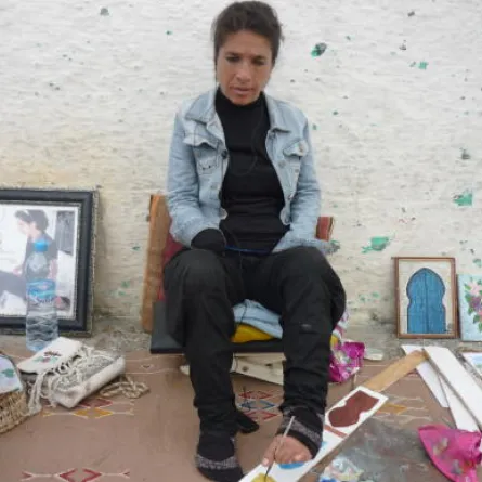 تشكيلية مغربية تتحدى الإعاقة وترسم برجلها