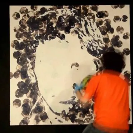 فنان يرسم باستخدام كرة قدم