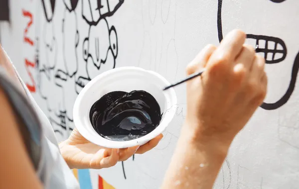 تطبيق عملي للطلاب بطمس الكتابة على الجدار واستبدال لوحات فنية بها