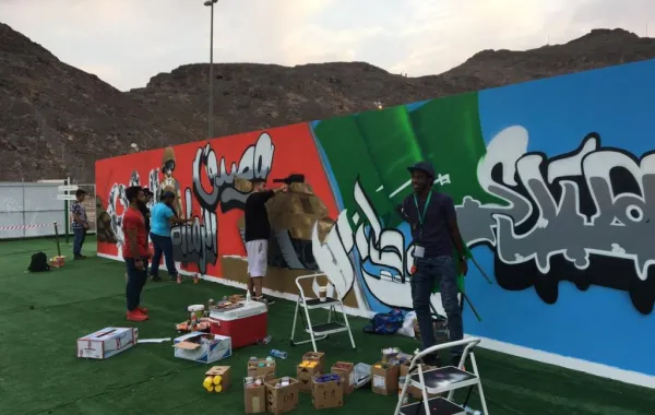 شباب سعوديون ينشئون جدارية «جرافيتي» لليوم الوطني
