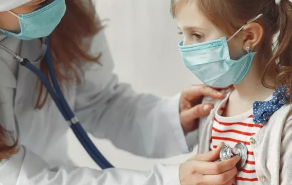 صورة لطبيبة تقيس معدل التنفس الصدري عند طفلة