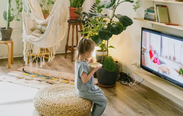 صورة لطفل يجلس بصحبة الشاشة