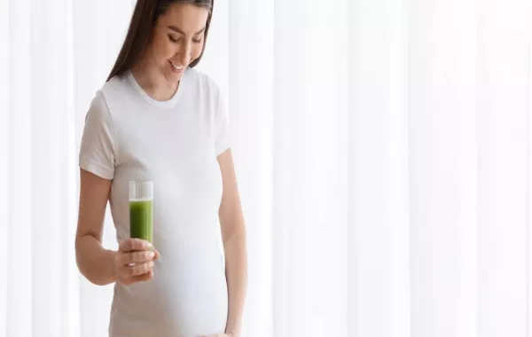 صورة لحامل تتناول العصير الأخضر
