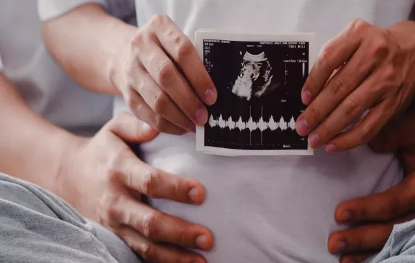 صورة لأم حامل تحمل صورة لأشعة السونار