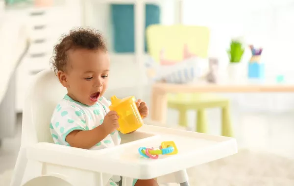 صورة لطفل يحاول الشرب من الكوب