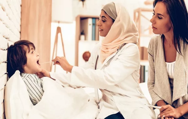 صورة لطبيبة تفحص طفلاً مريضاً