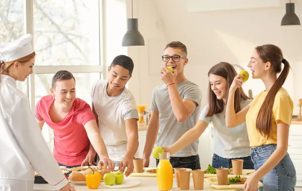 صورة لعدد من المراهقين يتناولون طعاماً صحياً