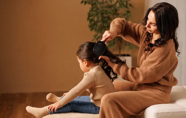 صورة أم تمشط شعر ابنتها
