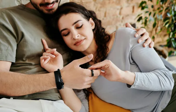 زوجة تتلمس بيدها أصابع زوجها برقة وتقضي وقتاً ممتعاً معه 