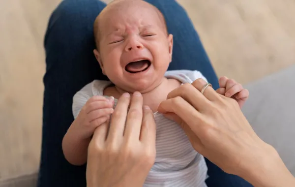 صورة لرضيع يبكي أثناء تغيير ملابسه