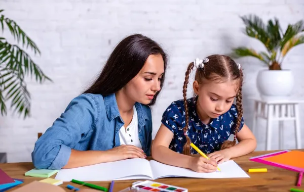 صورة لأم تدعم طفلتها في المذاكرة
