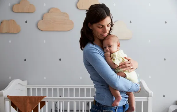 التوقف عن الرضاعة الليلية مرتبط بصحة الرضيع صورة لأم تحمل رضيعها ليلاً