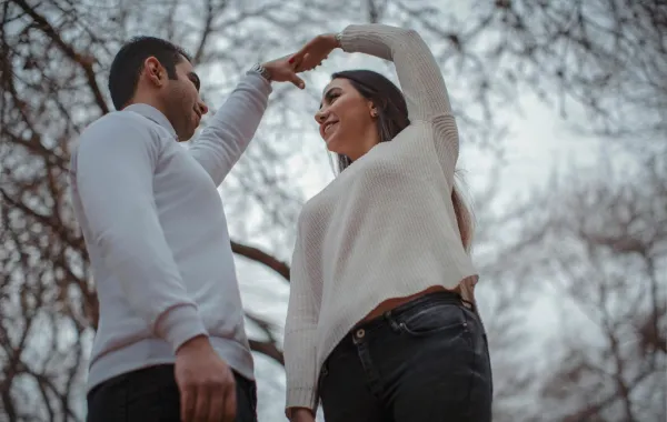 خطيبان يرقصان بسعادة ويرفعان أيديهما المتشابكة