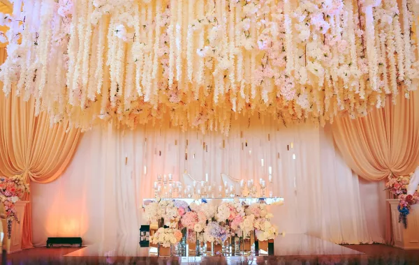 طاولة العريس والعروس مزينة بالورود والشموع (الصورة من freepik) حفل زفاف منظم داخل قاعة مقفلة