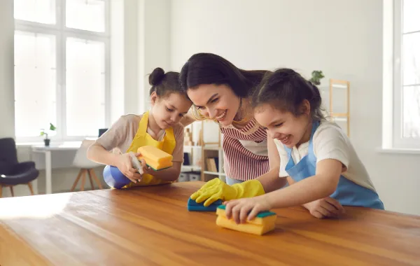 أم وابنتاها الصغيرتان تقومان بأعمال المنزل