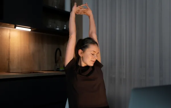 سيدة تقوم بحركات تمدّد بسيطة قبل النوم  Image By Freepik