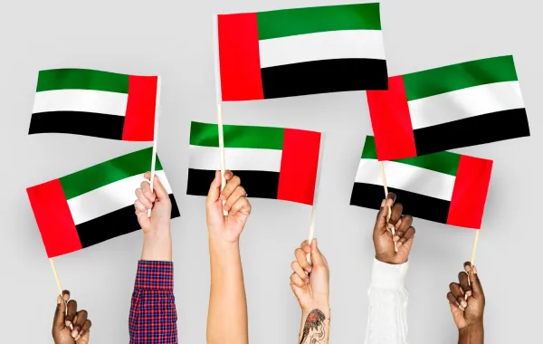 اطفال يرفعون العلم الاماراتي- مصدر الصورة freepik