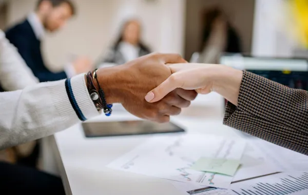 أحد العملاء يسلم على موظف يتسم بالنزاهة 