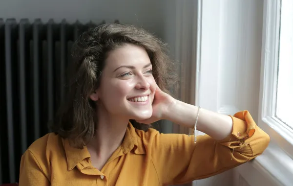 فتاة تبدو سعيدة تستقبل اليوم بمشاعر إيجابية وابتسامة 