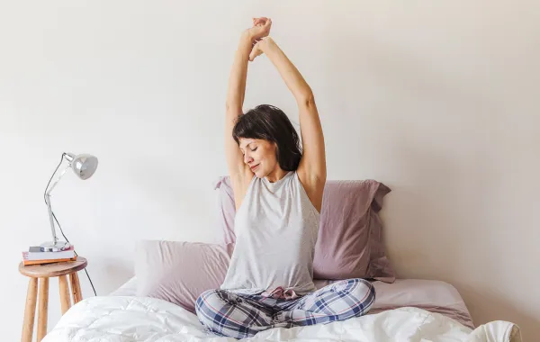 سيدة تقوم بحركات تمدّد بسيطة قبل النوم  Image By Freepik
