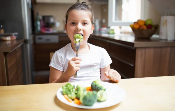 صورة لطفلة تأكل زهرات البروكلي