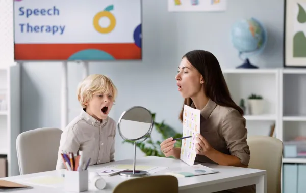 صورة لطفل لديه تأخر في النطق مع أخصائية نطق