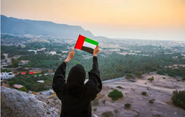 إماراتية تمسك علم بلدها بفخر