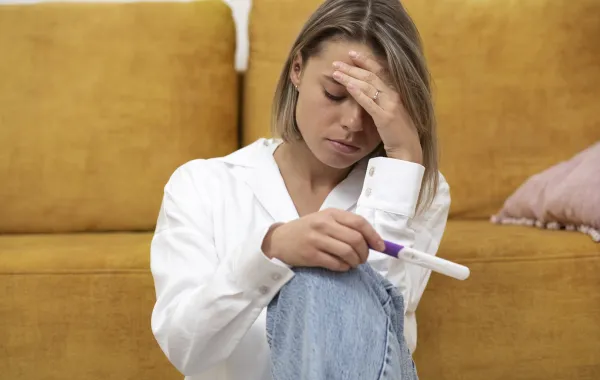 امرأة تشعر بالحزن لعدم إيجابية اختبار الحمل