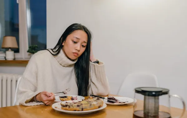 امرأة تشعر بالتوتر بعد تناول الطعام- المصدر: Pexels