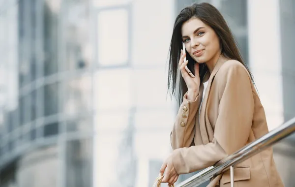 فتاة واثقة من نفسها قوية تتحدث في جهازها المحمول وتبتسم في ثقة