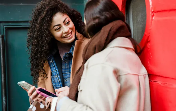 صديقتان تقرآن رسالة صباحية مبهجة عبر الموبايل