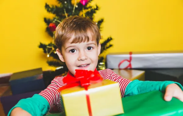 صورة لطفل سعيد مع هدايا العام الجديد