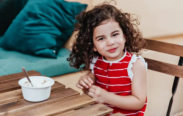 طفلة تتناول الزبادي
