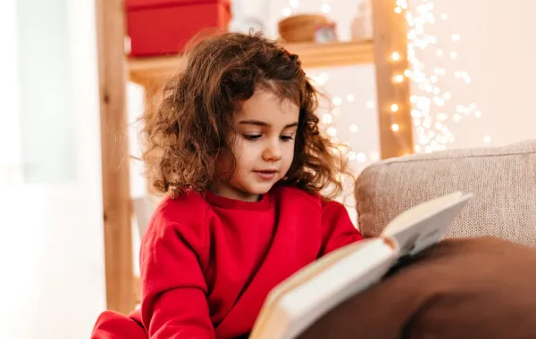 صورة لطفلة تمسك بالكتاب